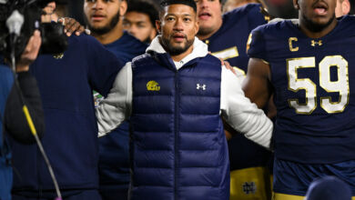 Notre Dame Fighting Irish head coach Marcus Freeman locks arms with his players.